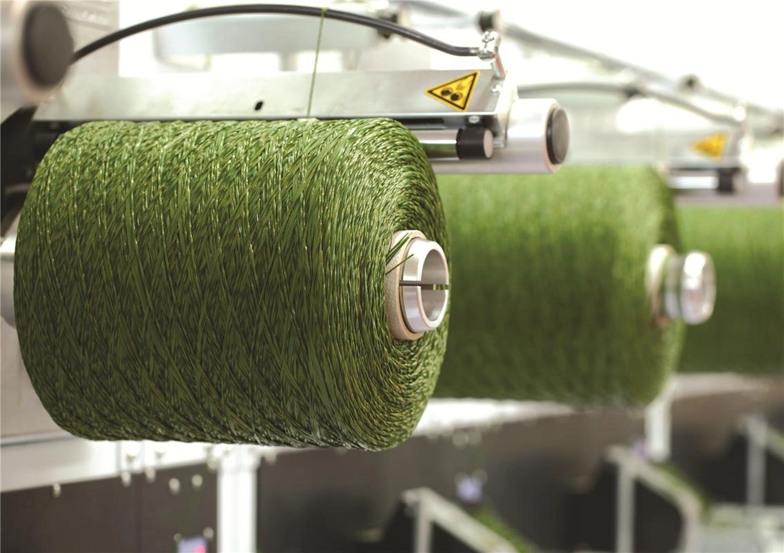 Bobinas de fibra sintética verde montadas en la línea de producción
